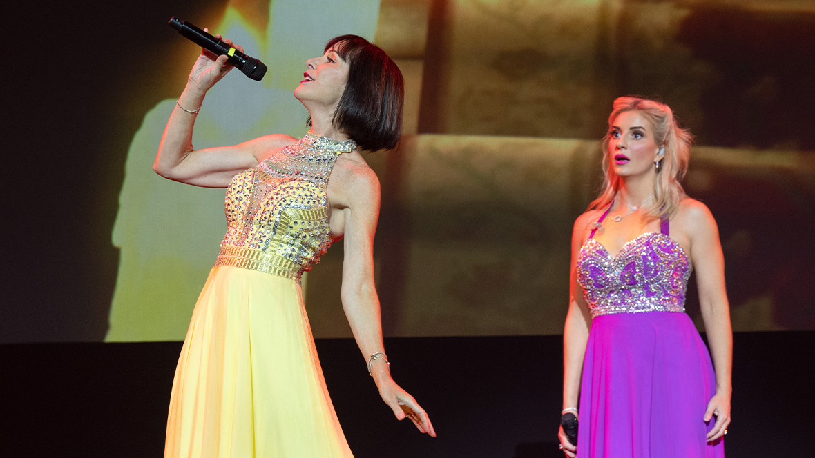 Disney Legend Susan Egan and Anneliese van der Pol perform onstage.