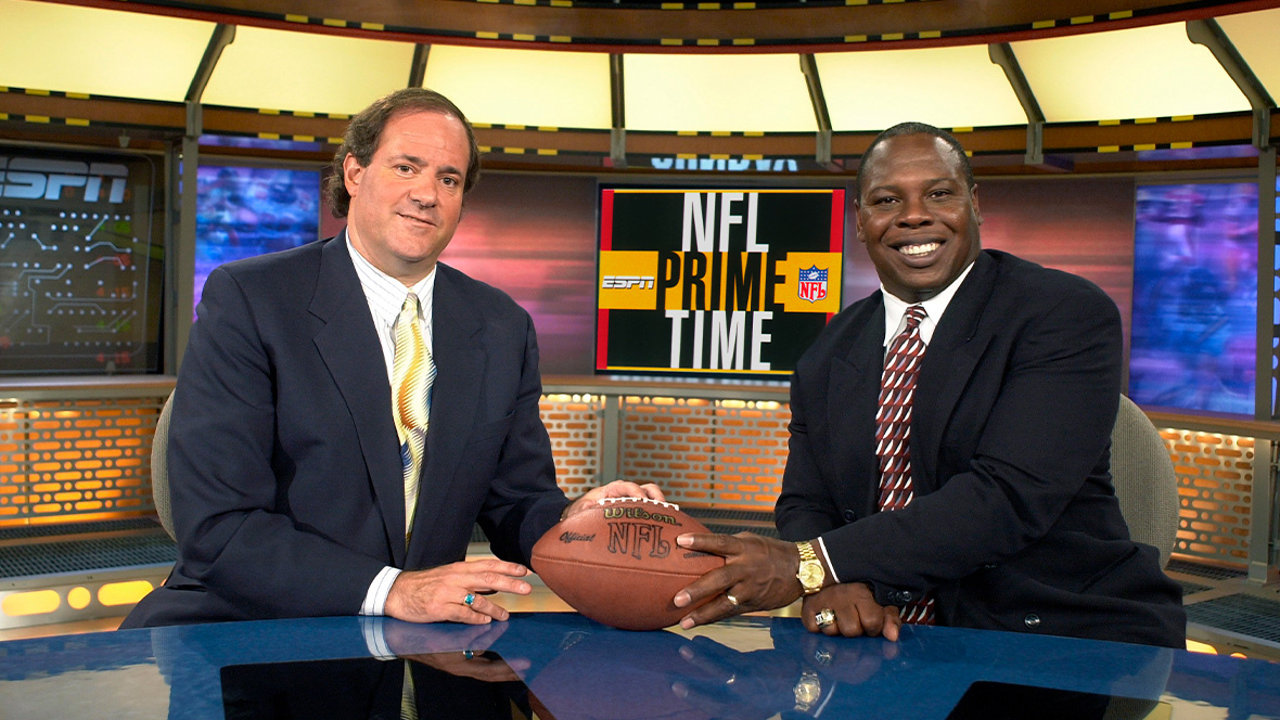 Disney Legend Chris Berman and Tom Jackson palm a football on the set of NFL Primetime.