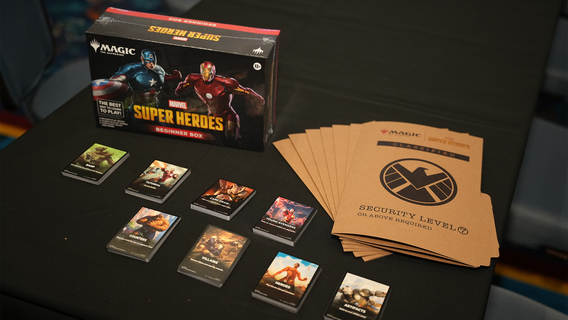 Magic: The Gathering Marvel Super Heroes Beginner Box displayed with card decks, play materials, and themed accessories.