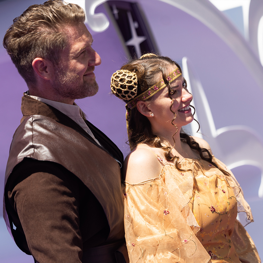 Two D23 attendees cosplaying as Anakin Skywalker and Padm&eacute; Amidala from Star Wars pose together at D23: The Ultimate Disney Fan Event.