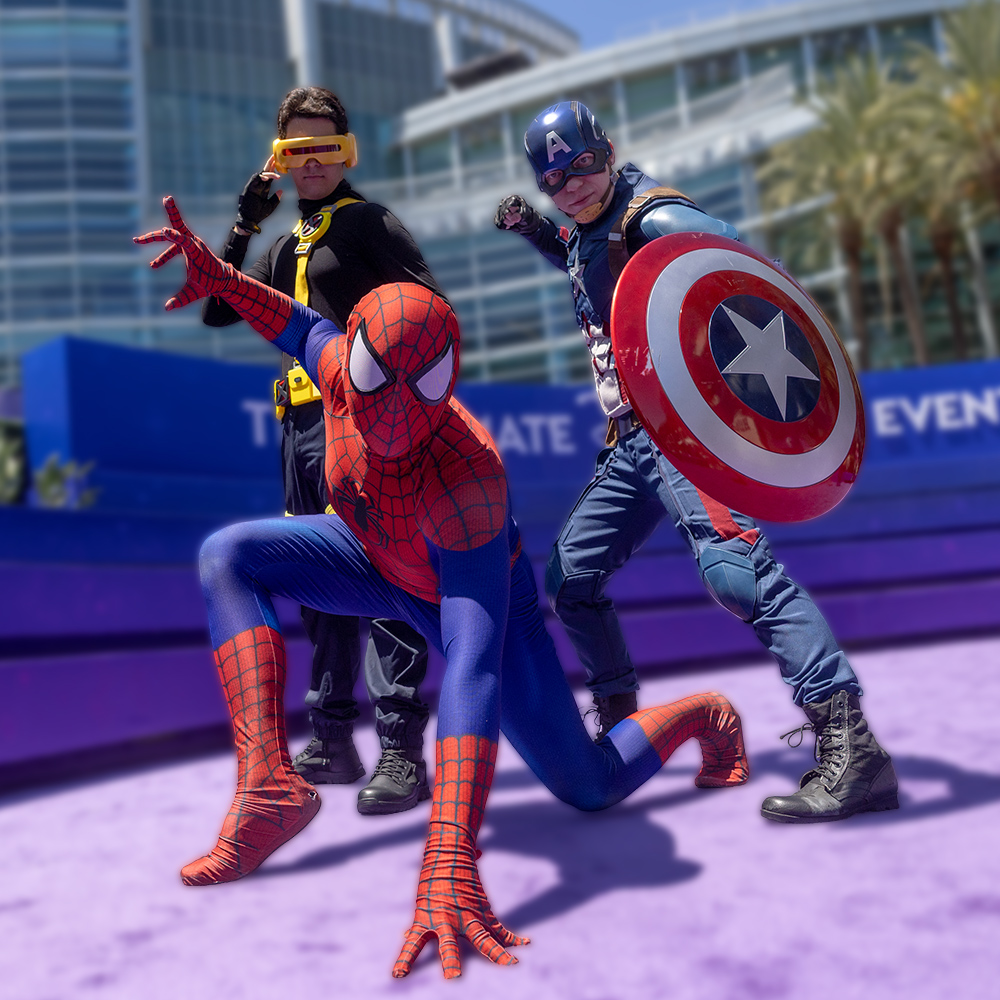 D23 attendees cosplaying as Spider-Man, Captain America, and Cyclops pose together at D23: The Ultimate Disney Fan Event.