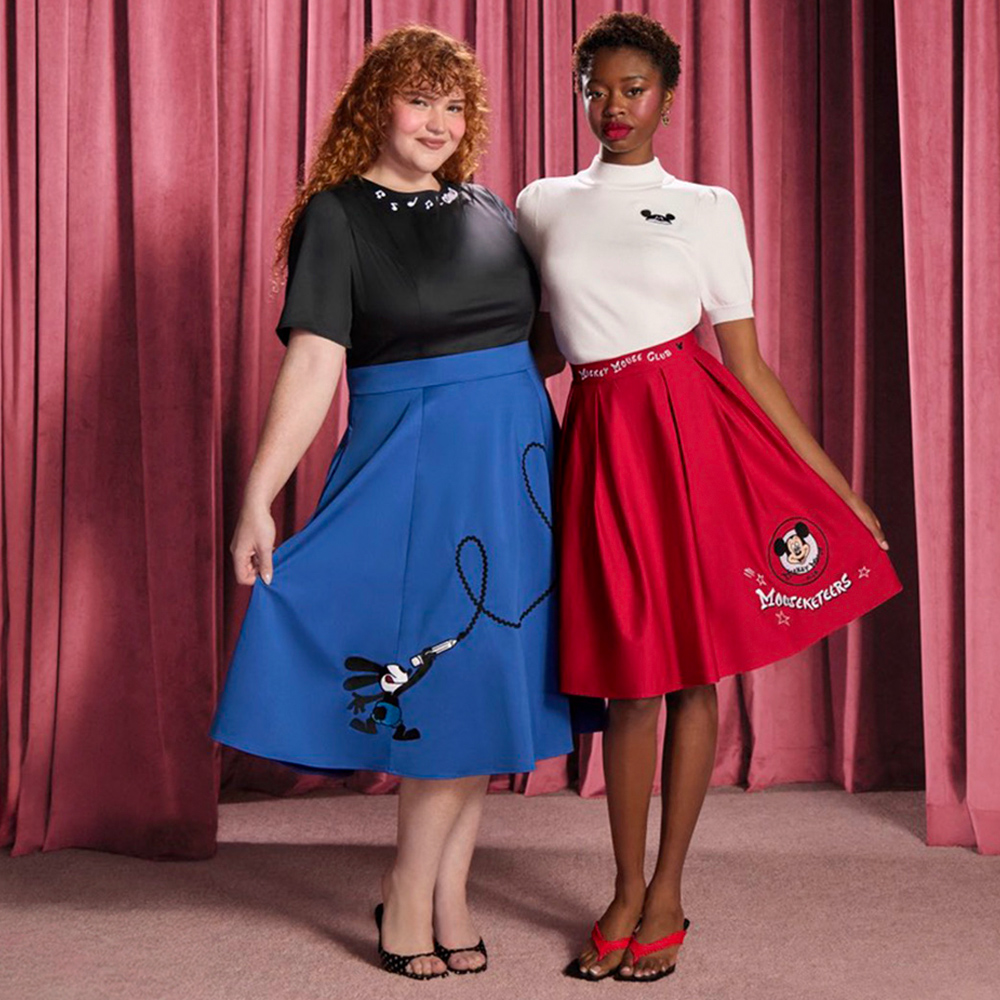 Two models display Disney-inspired skirts featuring Mickey Mouse Club and Oswald the Lucky Rabbit designs against a curtain backdrop.
