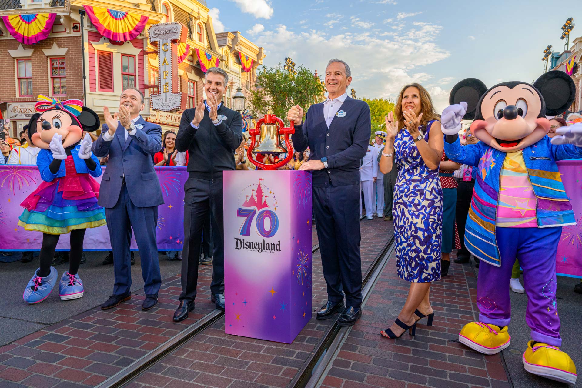 Disneyland Resort leaders and Disney characters gather around the ceremonial bell during the Disneyland Resort 70th anniversary celebration on Main Street, U.S.A.