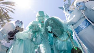 D23 attendees dressed as the Hitchhiking Ghosts from Haunted Mansion pose together during D23: The Ultimate Disney Fan Event.