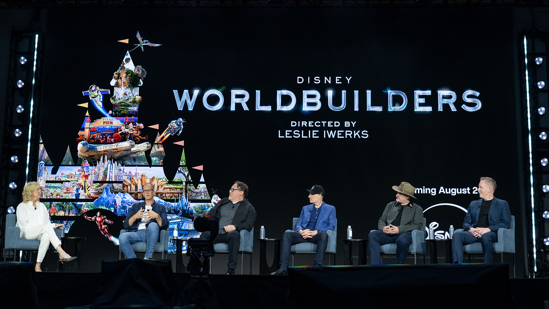 Panelists participate in a Disney Worldbuilders discussion onstage during D23: The Ultimate Disney Fan Event 2026, beneath a large screen displaying the documentary title and artwork.