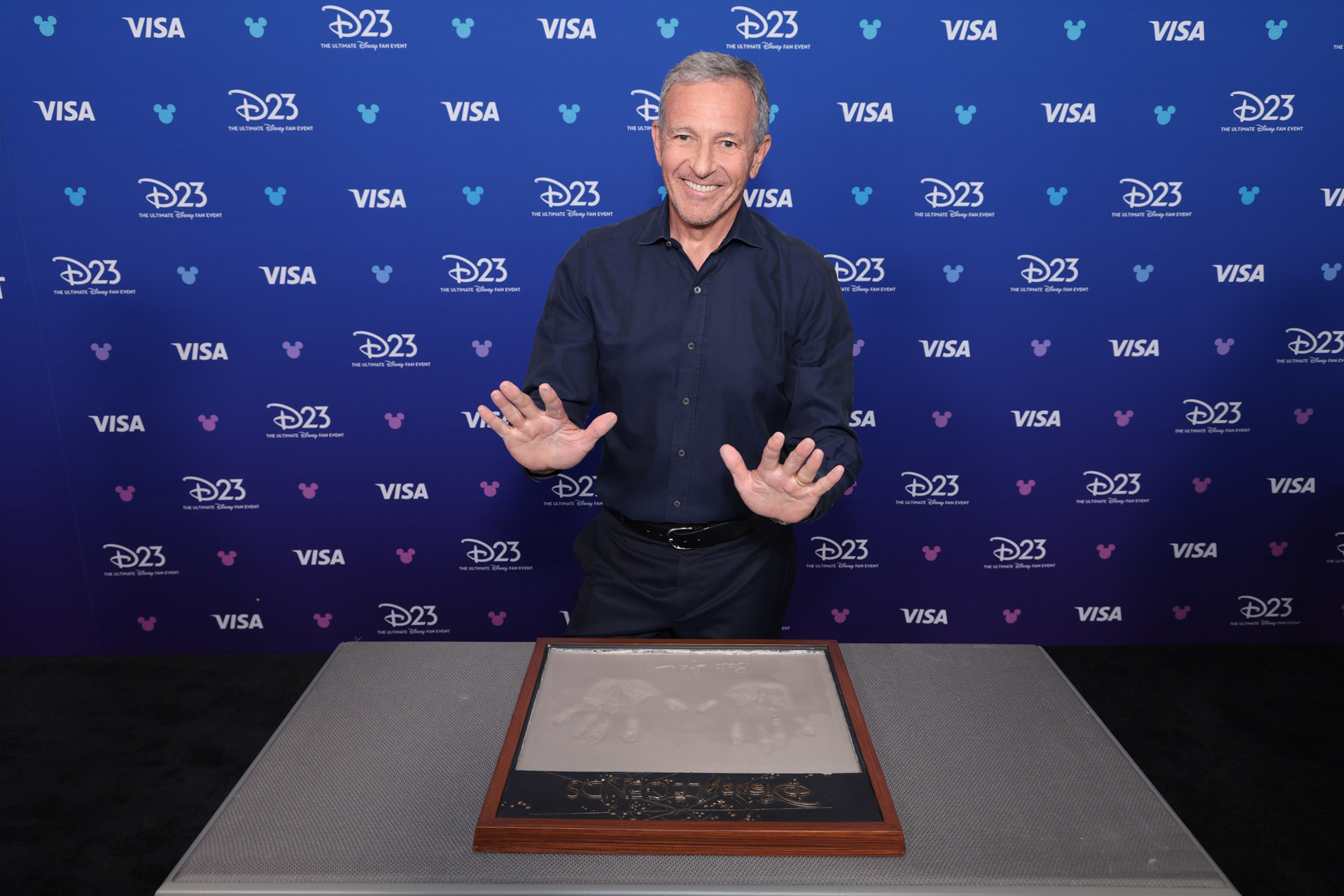 Bob Iger poses with his Disney Legends handprint plaque at D23: The Ultimate Disney Fan Event.