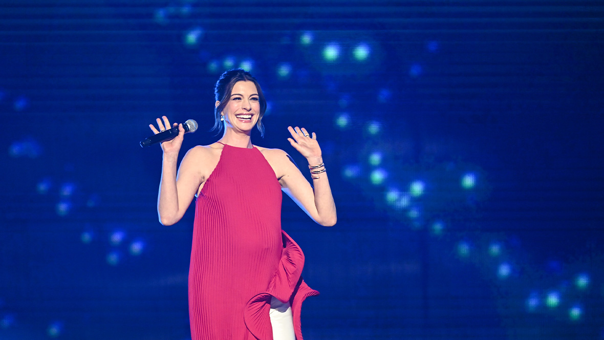 An image of Disney Legend Anne Hathaway on stage at the Honda Center during the Disney Entertainment Showcase at D23: The Ultimate Disney Fan Event 2026.