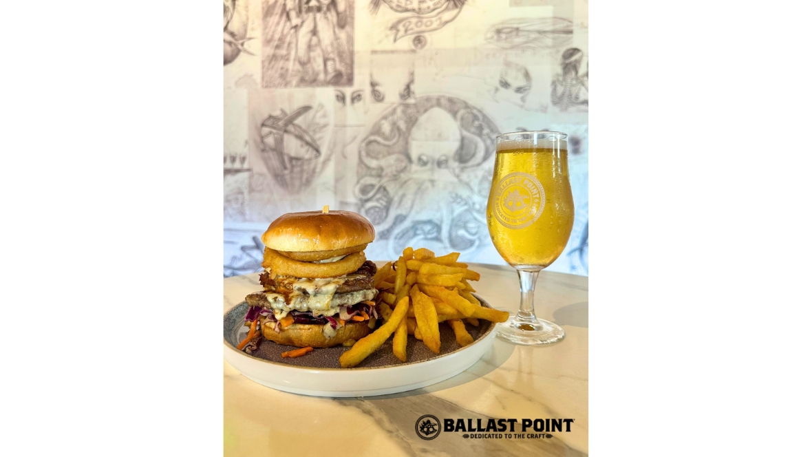A burger, fries, and Ballast Point beer are served on a table during the Hulu Animayhem dining promotion.