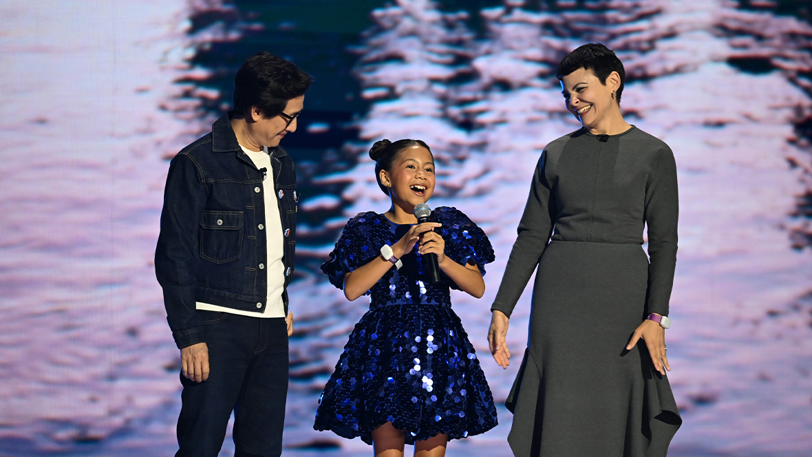 An image of Ke Huy Quan, Lilo & Stitch’s Maia Kealoha, and Ginnifer Goodwin on stage at the Honda Center during the Disney Entertainment Showcase at D23: The Ultimate Disney Fan Event 2026.