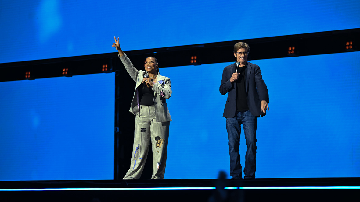 An image of Queen Latifah and Denis Leary on stage at the Honda Center during the Disney Entertainment Showcase at D23: The Ultimate Disney Fan Event, telling the crowd about Ice Age: Boiling Point.