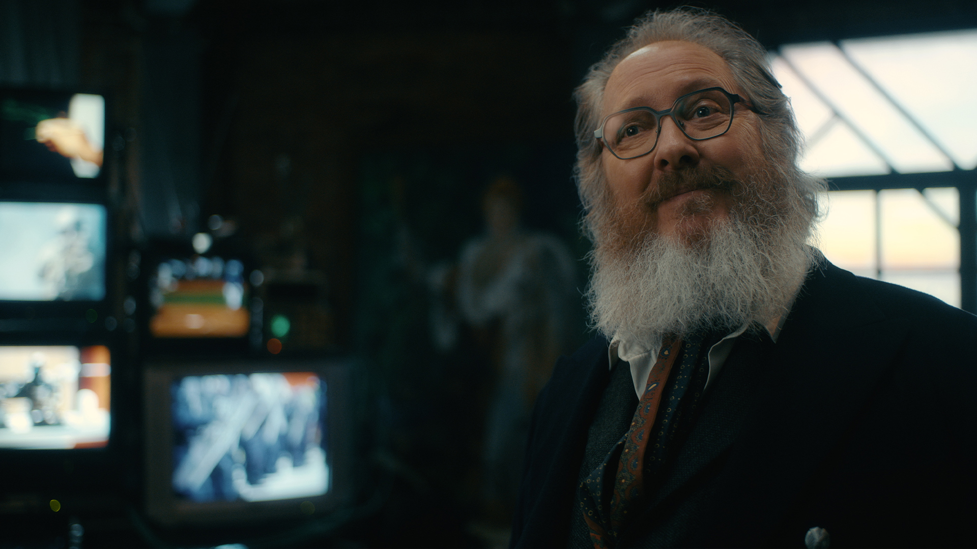 A bearded man stands among glowing monitors and laboratory equipment in a scene from VisionQuest.