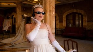 A D23 attendee dressed as Princess Diana from The Princess Diaries poses inside an elegant event space during D23: The Ultimate Disney Fan Event.