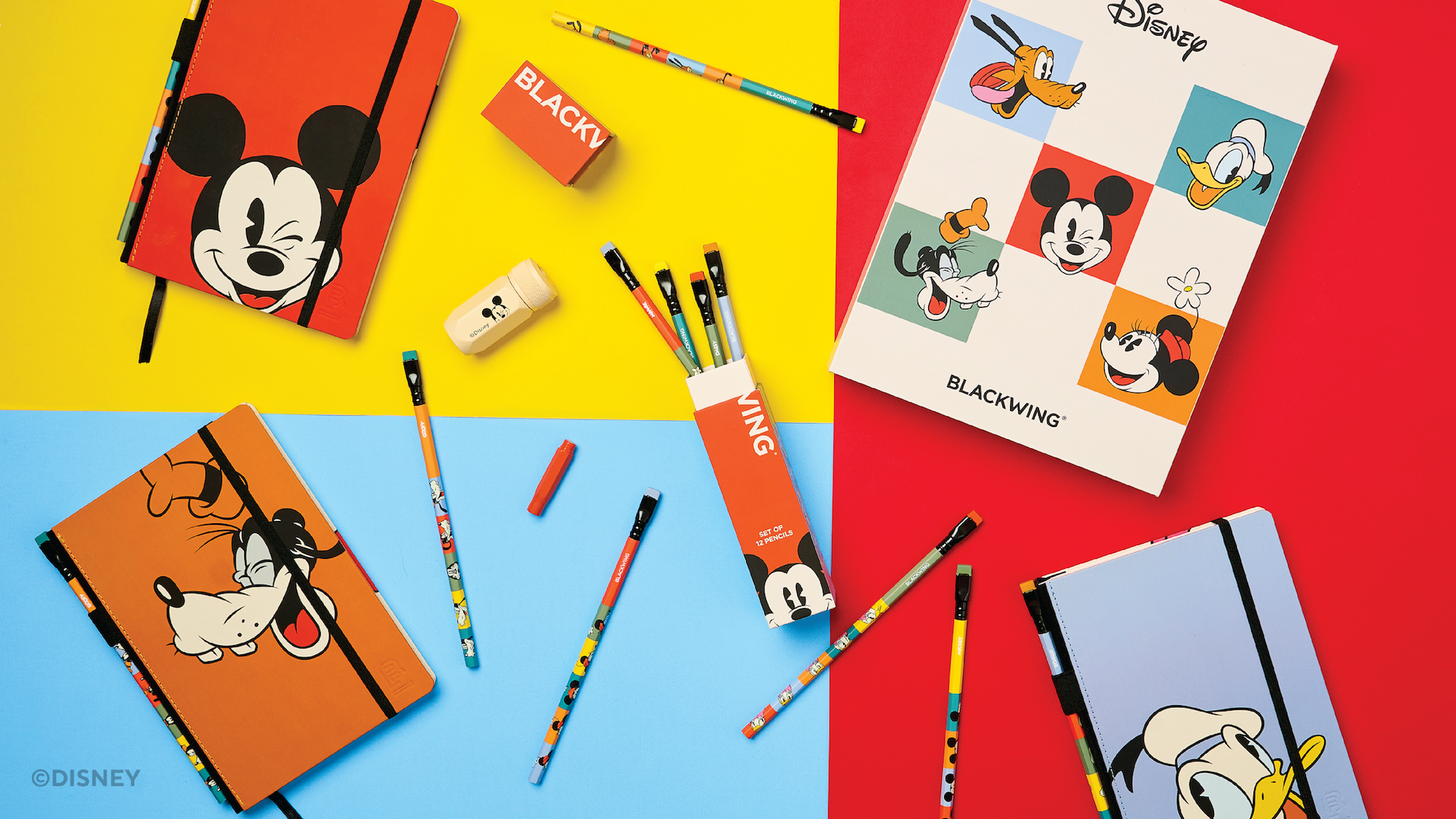Disney-themed Blackwing notebooks and pencils arranged on a colorful background.