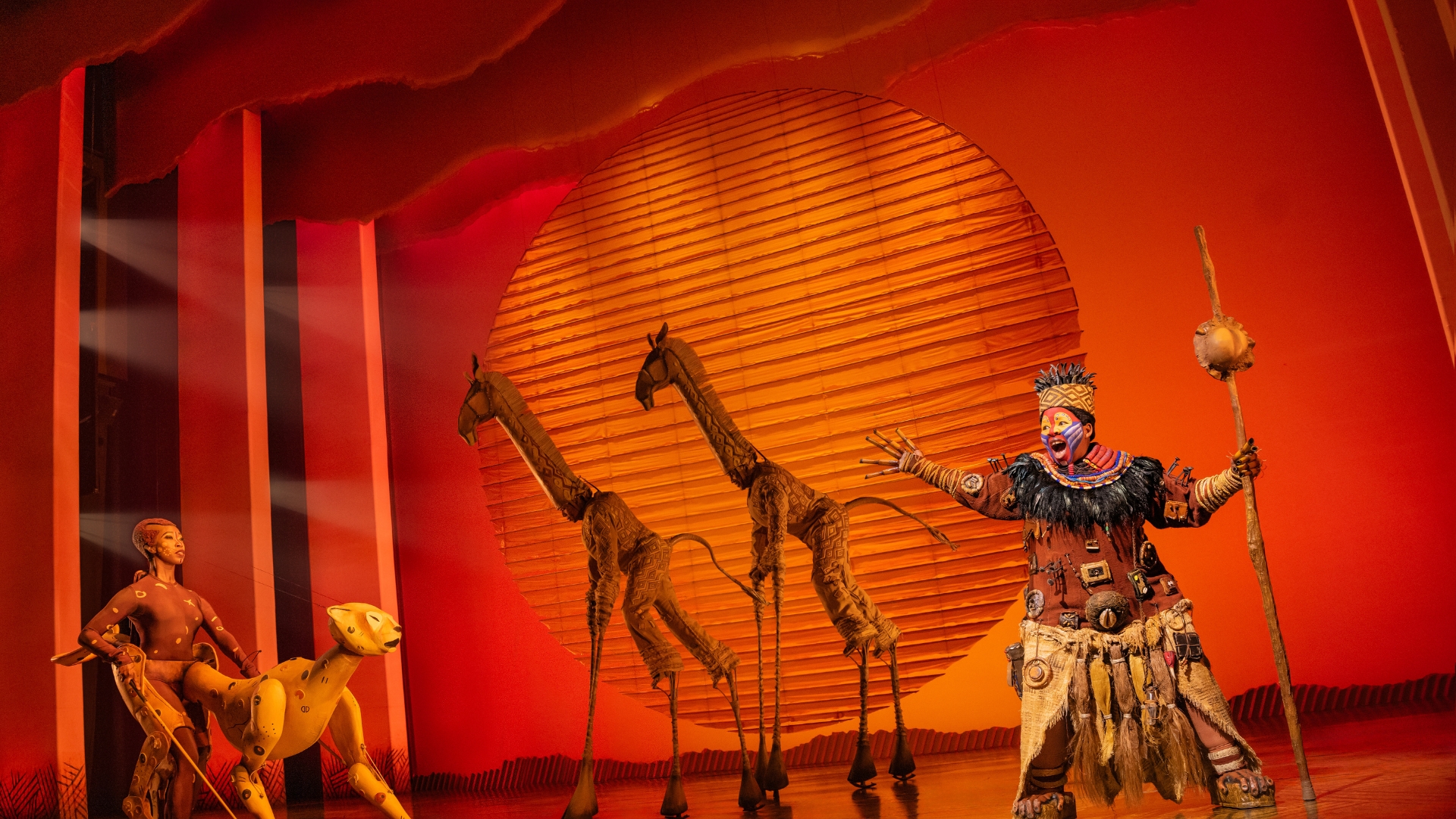 In an image from Disney Theatrical Group’s The Lion King on Broadway, Ntsepa Pitjeng-Molebatsi as Rafiki and company are seen during the “Circle of Life” opening number.