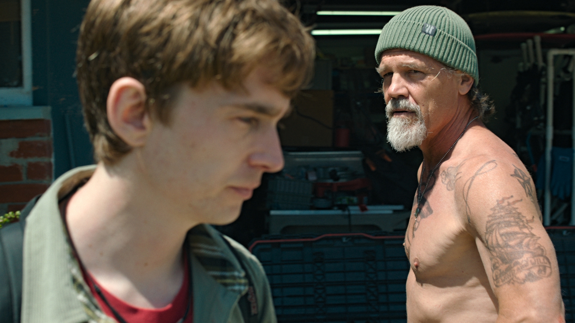 Jay Gardiner, played by Austin Abrams, looks away as a shirtless Mitt Gardiner, played by Josh Brolin, looks toward Jay in a scene from 20th Century Studios&rsquo; Whalefall.