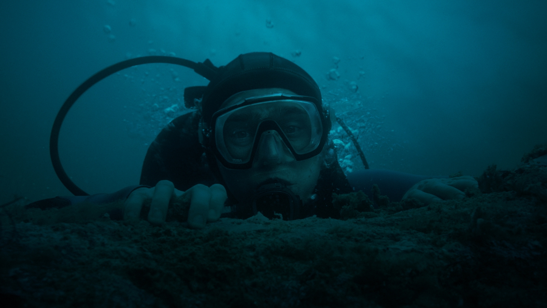 Jay Gardiner, played by Austin Abrams, wears scuba gear and peers over the reef&rsquo;s edge in a scene from 20th Century Studios&rsquo; Whalefall.